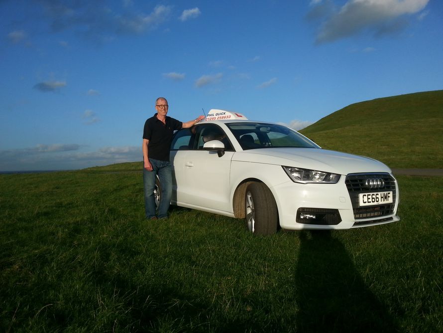 A man standing side with the audi car in grass